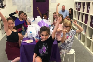 Children enjoying food and games at a cheerleading party