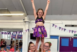 Child perfoming a stunt at a cheerleading party