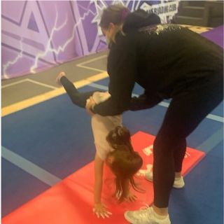 A young girl is enjoying learning gymnastics skills at a Cheer for Fun Preschool session