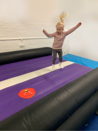 Toddler enjoying bouncing on the air track
